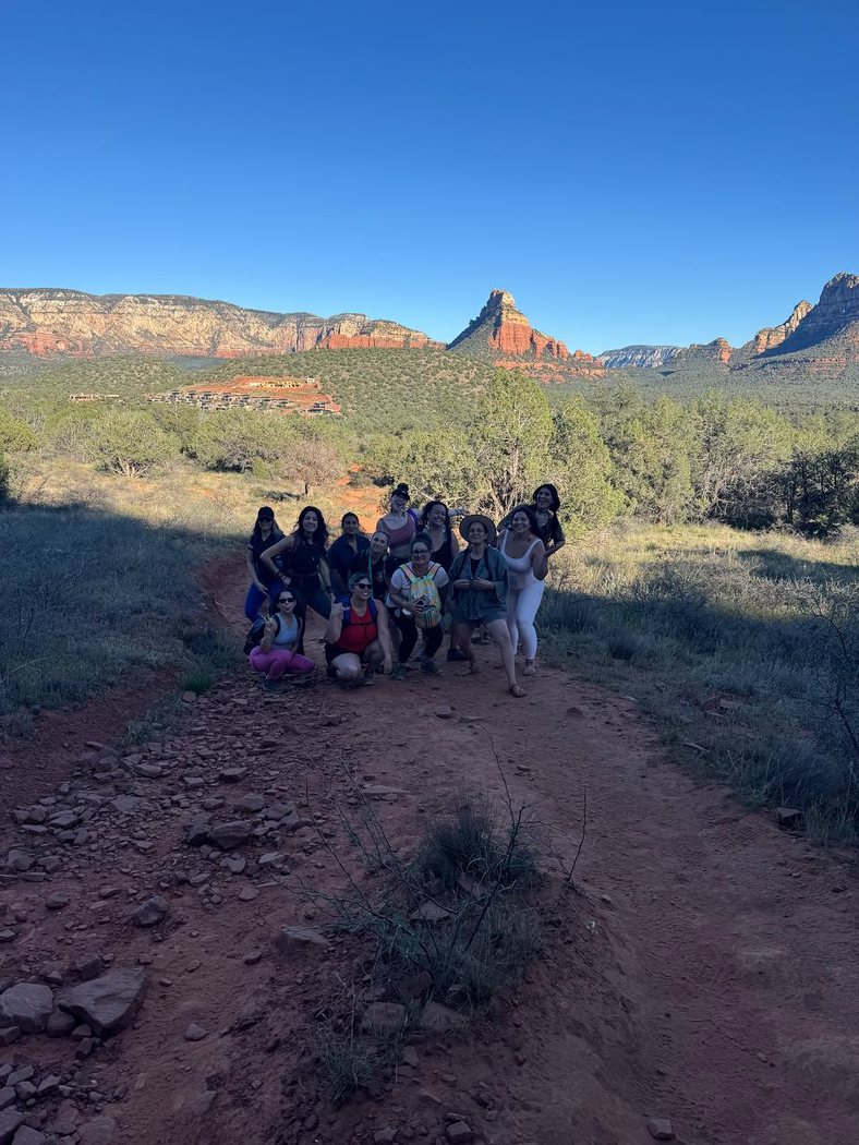 A group of women on a Sedona trail with red-rock views